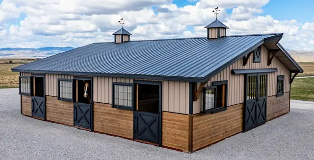 Two-piece horse barn with a horse looking out of an open Dutch door and two cupolas on the roof