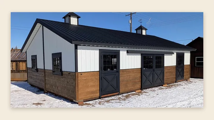24×36 two-piece horse barn in Helena with black Dutch doors, white siding, wood lower walls and a black metal roof